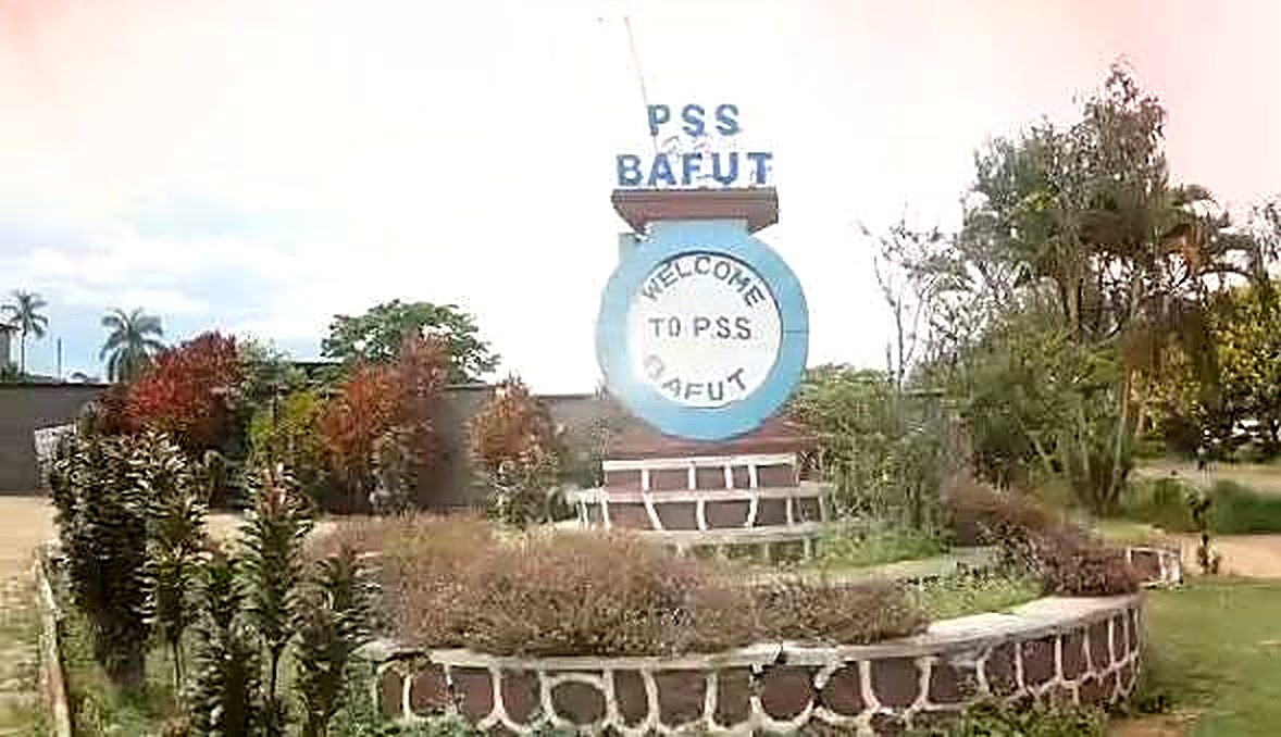 The PSS Bafut campus entrance at Agyati: the welcome sign on its stone plinth among flowering shrubs and palms